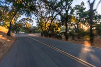 a blurred shot of some trees and a road in the background with a blurry image of an orange motorcycle