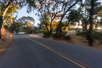 a blurred shot of some trees and a road in the background with a blurry image of an orange motorcycle