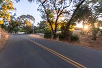 a blurred shot of some trees and a road in the background with a blurry image of an orange motorcycle