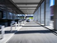 blurred photograph of a train station with cars moving by at high speed and blurry