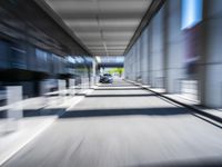 blurred photograph of a train station with cars moving by at high speed and blurry