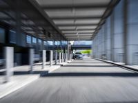 blurred photograph of a train station with cars moving by at high speed and blurry