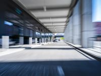 blurred photograph of a train station with cars moving by at high speed and blurry