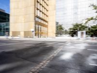 blurry view of a urban street with buildings in the background by a puddle of water