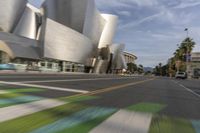 a blurry view of the city from a speeding car on a busy street with a green painted road marker