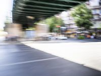 a blurry image of a bike riding down the street in front of a building