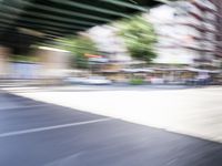 a blurry image of a bike riding down the street in front of a building