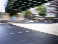 a blurry image of a bike riding down the street in front of a building