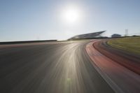 a blurry photo from the front of a car driving on an empty track with red and white stripeing