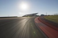 a blurry photo from the front of a car driving on an empty track with red and white stripeing