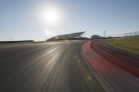 a blurry photo from the front of a car driving on an empty track with red and white stripeing