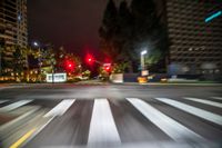 a traffic signal is red in a blurry city street at night time stock photo