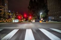 a traffic signal is red in a blurry city street at night time stock photo