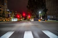 a traffic signal is red in a blurry city street at night time stock photo