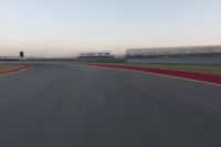 a blurry photo of a curve with one car going down it at dusk,