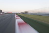 motion blurry of an asphalt race track as a motorcycle glides along the road