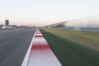 motion blurry of an asphalt race track as a motorcycle glides along the road