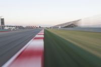 motion blurry of an asphalt race track as a motorcycle glides along the road