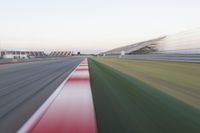 motion blurry of an asphalt race track as a motorcycle glides along the road