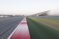 motion blurry of an asphalt race track as a motorcycle glides along the road