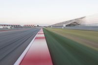 motion blurry of an asphalt race track as a motorcycle glides along the road