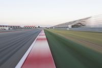 motion blurry of an asphalt race track as a motorcycle glides along the road