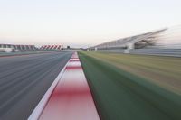 motion blurry of an asphalt race track as a motorcycle glides along the road