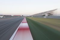 motion blurry of an asphalt race track as a motorcycle glides along the road