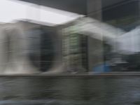 blurry photo of a car parked near an art museum by a river and building