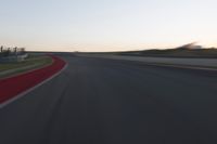 a blurry picture of a speed car on a race track with red tires running along the side of the track