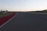 a blurry picture of a speed car on a race track with red tires running along the side of the track