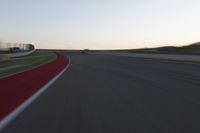 a blurry picture of a speed car on a race track with red tires running along the side of the track