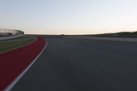 a blurry picture of a speed car on a race track with red tires running along the side of the track