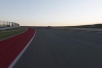 a blurry picture of a speed car on a race track with red tires running along the side of the track