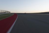 a blurry picture of a speed car on a race track with red tires running along the side of the track