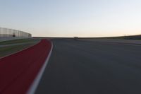 a blurry picture of a speed car on a race track with red tires running along the side of the track