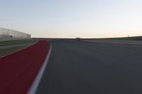 a blurry picture of a speed car on a race track with red tires running along the side of the track