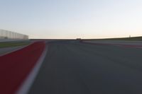 a blurry picture of a speed car on a race track with red tires running along the side of the track