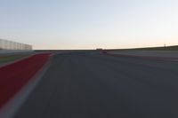 a blurry picture of a speed car on a race track with red tires running along the side of the track