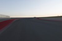 a blurry picture of a speed car on a race track with red tires running along the side of the track