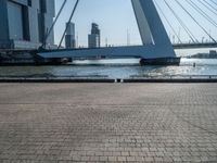 a yellow and white boat in the water next to buildings on a bridge with a few people around it