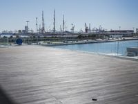a wooden floor on top of a boat dock near the water and many docked sailboats