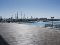 a wooden floor on top of a boat dock near the water and many docked sailboats