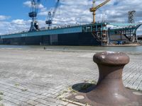 there is a boat docked in the port near a dock, and a post with it's ends at an angle of four