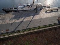 the boat is docked in the harbor next to the water dock with benches on it