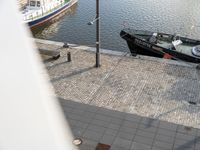 a boat and helicopter at the edge of a canal next to buildings and a body of water