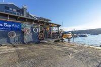 a boat house with an ocean and water scene in the background on the dock next to the boat