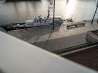 a large boat parked on top of a dock next to water's edge a city