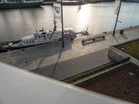 a large boat parked on top of a dock next to water's edge a city