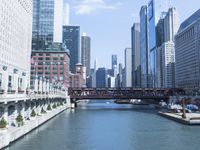 a large boat traveling down the river next to a big city skyline during the day